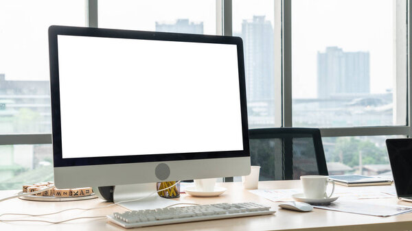 Пустой экран монитора компьютера для проектирования макета шаблона в современном небольшом офисном интерьере или домашнем офисе. Стильное рабочее место для творческой профессии.