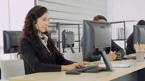 Geschäftsleute mit Headset arbeiten im Büro — Stockfoto