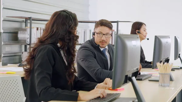 Uomini d'affari che indossano cuffie che lavorano in ufficio — Foto Stock