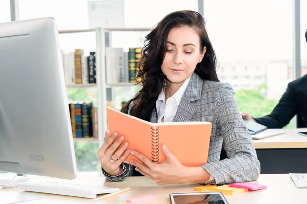 Mujer de negocios lee libro en escritorio de la oficina — Foto de Stock