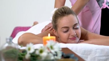 Kadın masaj terapistiyle masaj spası yaptırıyor..
