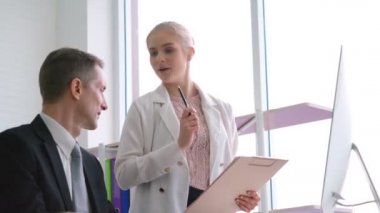 İki iş adamı ofiste proje stratejisi hakkında konuşuyor