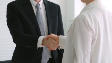 İş görüşmesinde iş arayan ve yönetici el sıkışması