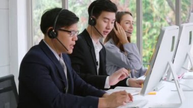 Ofiste çalışan kulaklık takan iş adamları.