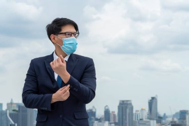 Coronavirus veya COVID-19 yüzünden yüz maskesi olan genç bir ofis çalışanı. Coronavirus veya COVID-19 'un yayılmasını engellemek ve işletmeyi yeniden açmak için koruyucu çalışma ortamı kavramı.