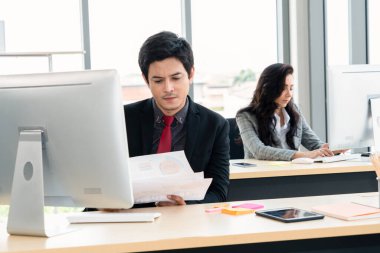 Modern ofis odasındaki masada çalışan iş adamları mali veri raporlarını incelerken .