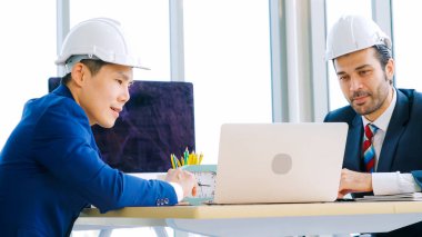 Mühendis ve mimar, mühendislik ve mimari proje planlaması hakkında ofis masasında bir araya geldiler. .