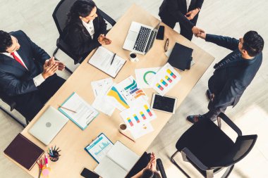 İş adamları grup toplantısı ofiste yukarıdan çekildi. İş kadınları, iş adamları ve ofis çalışanları, proje planlama belgeleriyle takım konferansında toplantı masasında çalışıyorlar. .