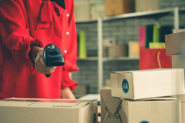 Çevrimiçi satıcı ev ofisinde çalışıyor ve teslimat kutusunu müşteriye paketliyor. İnternette e-ticaret yapan küçük işletme sahibi ya da girişimci.
