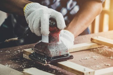 Marangoz atölyede ahşap işçiliği yapıyor. İnşaat malzemesi ya da ahşap mobilya üretiyor. Genç Asyalı marangoz zanaat için profesyonel araçlar kullanır. DIY üreticisi ve marangozluk konsepti.