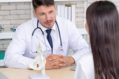 Profesyonel üniformalı doktor hastanedeki ya da klinikteki hastayı muayene ediyor. Sağlık, sağlık ve doktor hizmetleri konsepti.