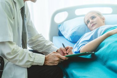 Profesyonel üniformalı doktor hastanedeki ya da klinikteki hastayı muayene ediyor. Sağlık, sağlık ve doktor hizmetleri konsepti.