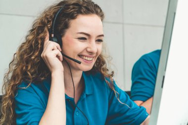 Ofiste çalışan kulaklık takan işadamları uzak müşteri ya da meslektaşlarını desteklemek için çalışıyorlar. Arama merkezi, tele pazarlama, müşteri destek acentesi telefon görüşmesinde hizmet sunar.