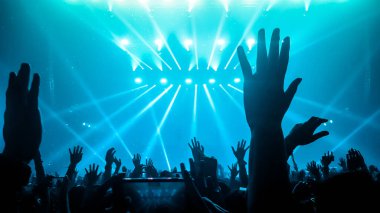 Mutlu insanlar gece kulübü DJ parti konserinde dans eder ve sahnede DJ 'den elektronik dans müziği dinlerler. Siluet dolu neşeli kalabalık 2020 yılbaşı partisini kutluyor. İnsanların yaşam tarzı DJ gece hayatı.