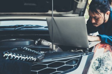Oto tamirhanesinde araba tamiri ve bakım hizmeti veren profesyonel bir tamirci. Araba servisi iş konsepti.