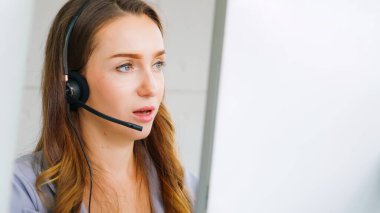 Ofiste çalışan kulaklık takan işadamları uzak müşteri ya da meslektaşlarını desteklemek için çalışıyorlar. Arama merkezi, tele pazarlama, müşteri destek acentesi telefon görüşmesinde hizmet sunar.