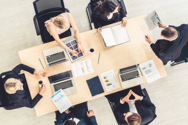 İş adamları grup toplantısı ofiste yukarıdan çekildi. İş kadınları, iş adamları ve ofis çalışanları, proje planlama belgeleriyle takım konferansında toplantı masasında çalışıyorlar. .