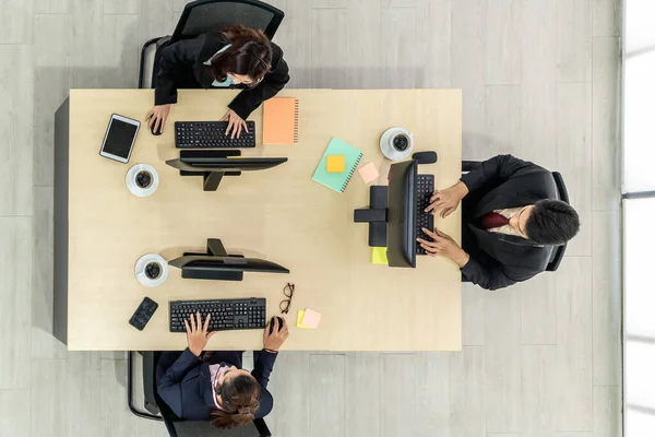 Business people wearing headset from top view in office working with computer to support remote customer or colleague. Call center, telemarketing agent service on telephone or video conference call.