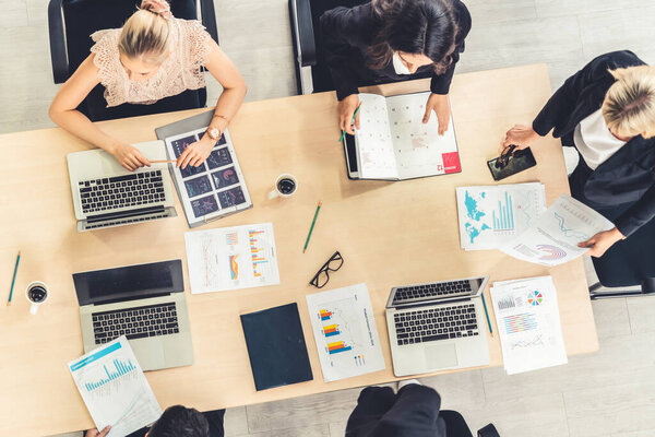 Business people group meeting shot from top view in office . Profession businesswomen, businessmen and office workers working in team conference with project planning document on meeting table .