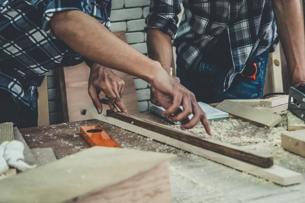 Carpenter working on wood craft at workshop to produce construction material or wooden furniture. The young Asian carpenter use professional tools for crafting. DIY maker and carpentry work concept.