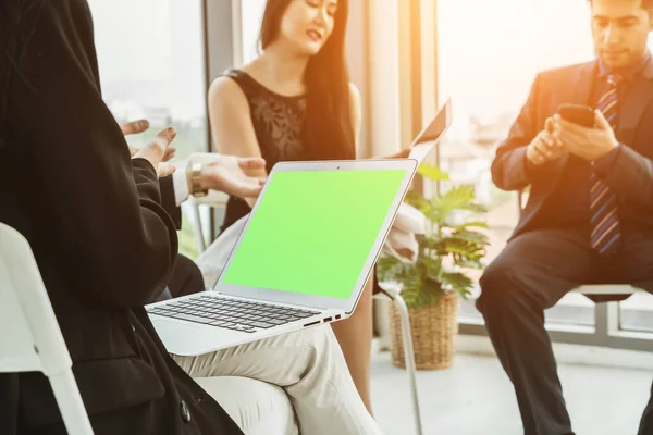 Business people in the conference room with green screen chroma key TV or computer on the office table. Diverse group of businessman and businesswoman in meeting on video conference call .