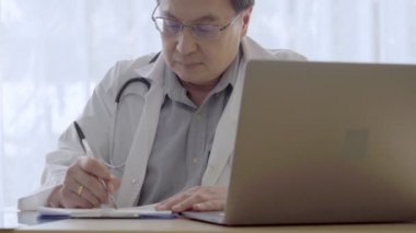 Hastane ofisinde hasta sağlığı verileriyle çalışan bir doktor..