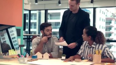 Yaratıcı iş adamları grubu iş yerindeki ofis masasında sohbet ediyorlar..