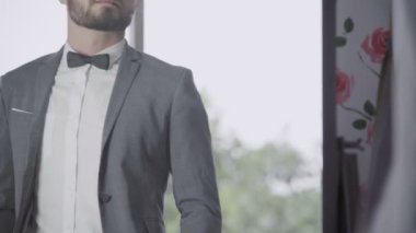 Resmi takım elbiseli adam iş ya da düğün için soyunma odasında giyiniyor..