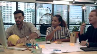 Yaratıcı iş adamları grubu iş yerindeki ofis masasında sohbet ediyorlar..