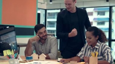 Yaratıcı iş adamları grubu iş yerindeki ofis masasında sohbet ediyorlar..