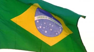 Brezilya bayrağı beyaz arkaplanda dalgalanıyor.