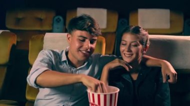 Erkekler ve kadınlar patlamış mısır yiyor ve atıyorlar.