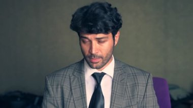 Orta yaşlı bir adam kameraya bakıyor.