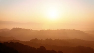 Gün batımı dağların ve tepelerin üzerinde kayboluyor