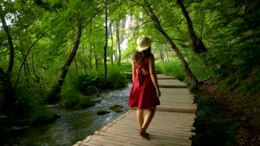 Kadın gezgin Plitvice Göllerinde şelalenin tadını çıkarıyor