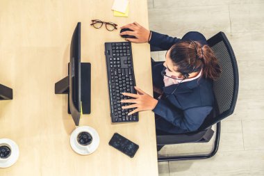 Ofiste üst kademeden kulaklık takan işadamları uzak müşteri ya da meslektaşlarını desteklemek için bilgisayarla çalışıyorlar. Çağrı merkezi, tele pazarlama acente servisi telefon ya da video konferans çağrısı.