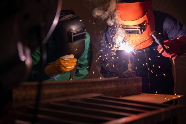 Metal welding steel works using electric arc welding machine to weld steel at factory. Metalwork manufacturing and construction maintenance service by manual skill labor concept. clipart