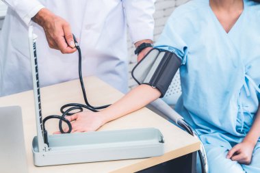 Profesyonel üniformalı doktor hastanedeki ya da klinikteki hastayı muayene ediyor. Sağlık, sağlık ve doktor hizmetleri konsepti.