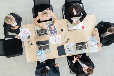 İş adamları grup toplantısı ofiste yukarıdan çekildi. İş kadınları, iş adamları ve ofis çalışanları, proje planlama belgeleriyle takım konferansında toplantı masasında çalışıyorlar. .