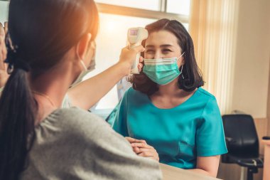 Ofiste ya da hastanede konuşurken resepsiyonist ve misafir maske takıyor. Covid 19 ve Coronavirus enfeksiyon koruması ve koruma politikası kavramı .