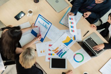 İş adamları grup toplantısı ofiste yukarıdan çekildi. İş kadınları, iş adamları ve ofis çalışanları, proje planlama belgeleriyle takım konferansında toplantı masasında çalışıyorlar. .