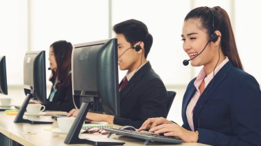 Ofiste çalışan kulaklık takan işadamları uzak müşteri ya da meslektaşlarını desteklemek için çalışıyorlar. Arama merkezi, tele pazarlama, müşteri destek acentesi telefon görüşmesinde hizmet sunar.