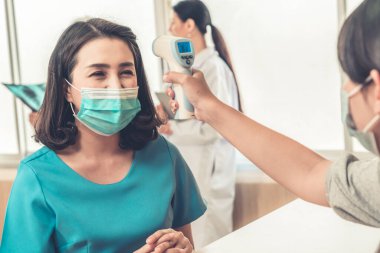 Ofiste ya da hastanede konuşurken resepsiyonist ve misafir maske takıyor. Covid 19 ve Coronavirus enfeksiyon koruması ve koruma politikası kavramı .