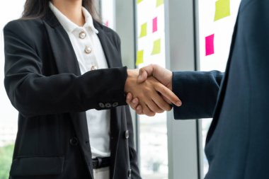 Şirket ofisinde iş adamlarının el sıkışması mali anlaşma konusunda profesyonel bir anlaşma gösteriyor.