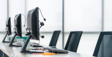 Çağrı merkezi bilgisayarları ve kulaklıklar ofiste. Telefon görüşmesinde tele pazarlama ve müşteri destek acentesi hizmetleri sunar.