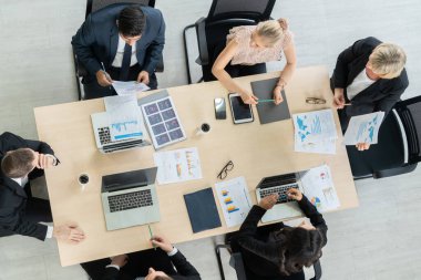 İş adamları grup toplantısı ofiste yukarıdan çekildi. İş kadınları, iş adamları ve ofis çalışanları, proje planlama belgeleriyle takım konferansında toplantı masasında çalışıyorlar. .
