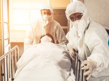 Acil servis doktoru ve doktor hastayı hastanedeki acil servise götürüyor. Doktor koronavirüs ve covid 19 koruma ve karantina kavramında koruyucu giysi ve yüz maskesi takıyor. .