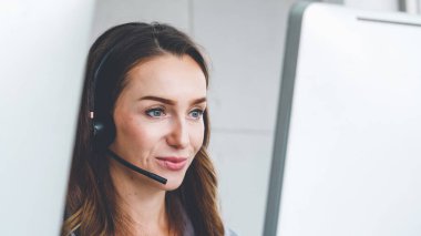 Ofiste çalışan kulaklık takan işadamları uzak müşteri ya da meslektaşlarını desteklemek için çalışıyorlar. Arama merkezi, tele pazarlama, müşteri destek acentesi telefon görüşmesinde hizmet sunar.
