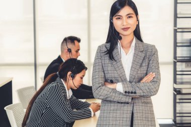 Ofiste çalışan kulaklık takan işadamları uzak müşteri ya da meslektaşlarını desteklemek için çalışıyorlar. Arama merkezi, tele pazarlama, müşteri destek acentesi telefon görüşmesinde hizmet sunar.