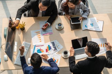 İş adamları grup toplantısı ofiste yukarıdan çekildi. İş kadınları, iş adamları ve ofis çalışanları, proje planlama belgeleriyle takım konferansında toplantı masasında çalışıyorlar. .